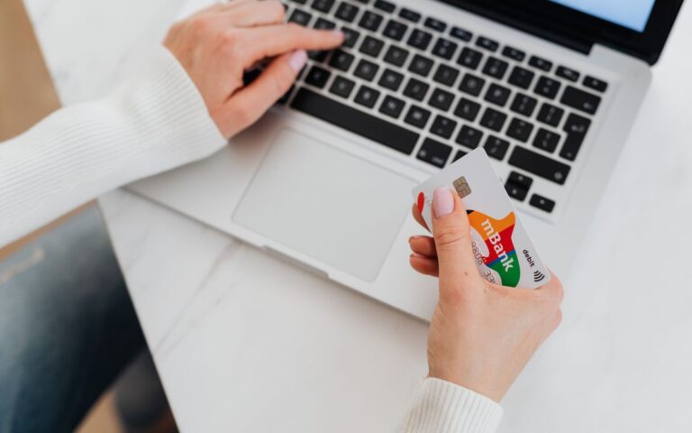 Online winkelen met een laptop en een betaalpas in de hand
